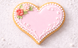 Heart-shaped cookie with pink icing, white pearls, and floral decorations on a light background from a 2 inch Heart Metal Cookie Cutter