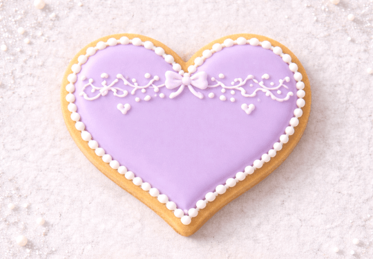 Heart-shaped cookie with purple icing and white decorations on a light background from a 1.75 inch Mini Heart Metal Cookie Cutter