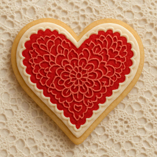Heart-shaped cookie with red floral design on a textured beige background from a 1.75 inch Mini Heart Metal Cookie Cutter