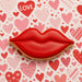 Red lip-shaped cookie on a background of hearts with 'LOVE' text from a 5 inch Lips Metal Cookie Cutter
