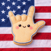 Toy hand making a peace sign with a smiley face on an American flag background from a  4 inch Love Sign Language Metal Cookie Cutter
