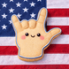 Toy hand making a peace sign with a smiley face on an American flag background from a  4 inch Love Sign Language Metal Cookie Cutter