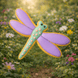 Decorative dragonfly cookie with purple wings and green body against a floral background from a 3.5 inch Dragonfly Metal Cookie Cutter