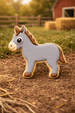Horse-shaped cookie on a dirt ground with a barn and hay bales in the background from a 3.75 inch Donkey Metal Cookie Cutter