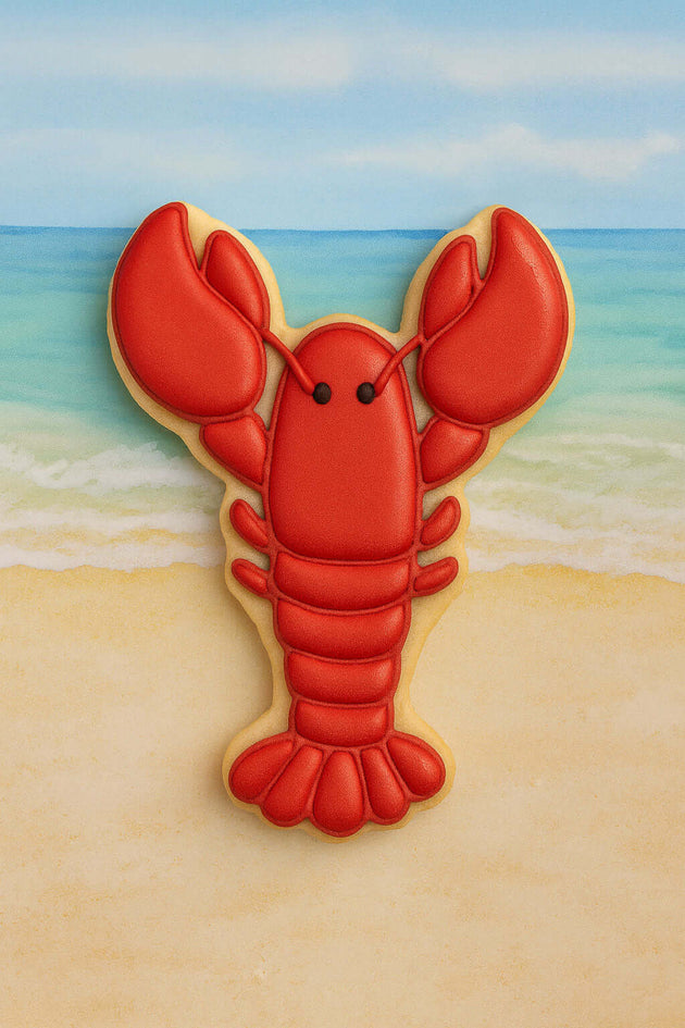 4 inch Lobster or Crawfish Metal Cookie Cutter shaped cookie on a beach background.