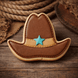 Cowboy hat cookie with a blue star on a wooden surface from a 4 inch Cowboy Hat Metal Cookie Cutter