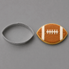 A football-shaped metal cookie cutter shown next to a decorated football-shaped sugar cookie on a smooth gray background from a 3.5 inch Football Metal Cookie Cutter