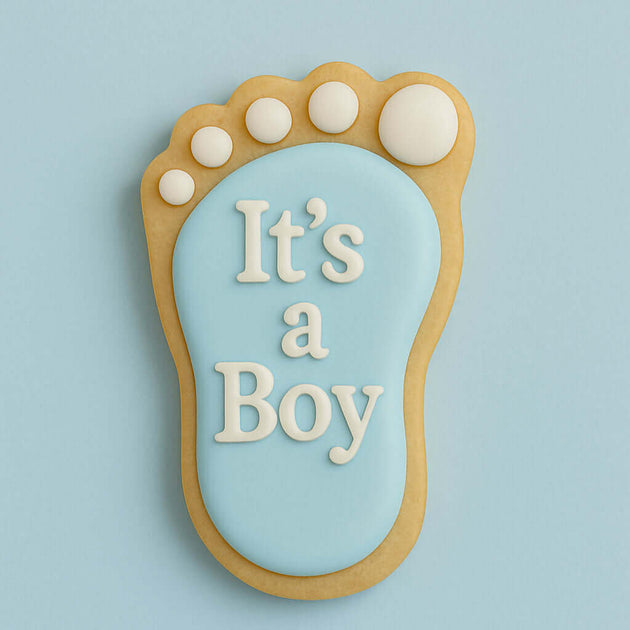 Decorative cookie shaped like a baby footprint with 'It's a Boy' text on a light blue background from a 3.5 inch Left Foot Metal Cookie Cutter