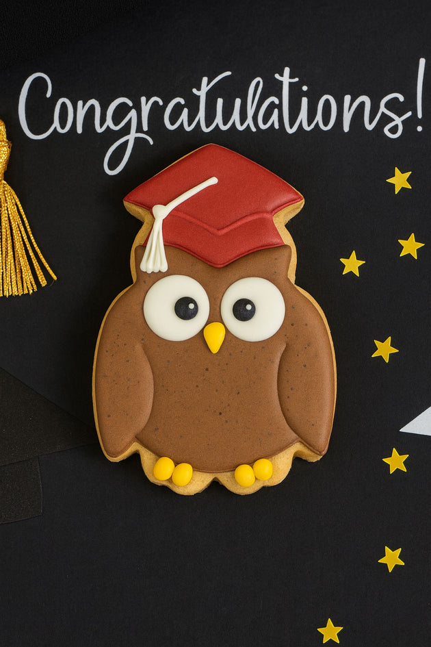 Owl cookie with graduation cap and tassel on a black background with 'Congratulations!' text