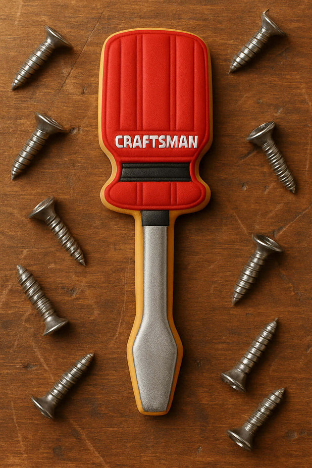 5 inch Screwdriver Metal Cookie Cutter with red handle and silver tip, surrounded by metal screws on wooden surface.