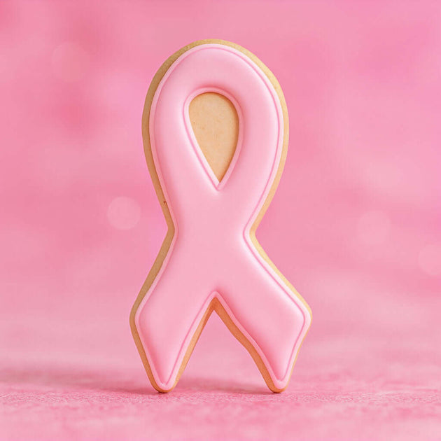 3.75 inch Awareness Ribbon Metal Cookie Cutter shaped pink cookie on a pastel pink background.