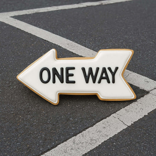One way sign on a road with white lines