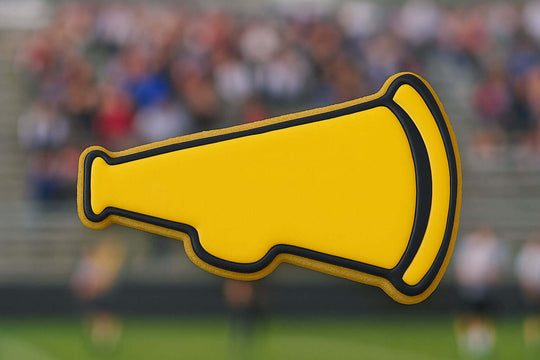 Yellow megaphone shape with black outline on a blurred sports event background from a 3.5 inch Megaphone Metal Cookie Cutter