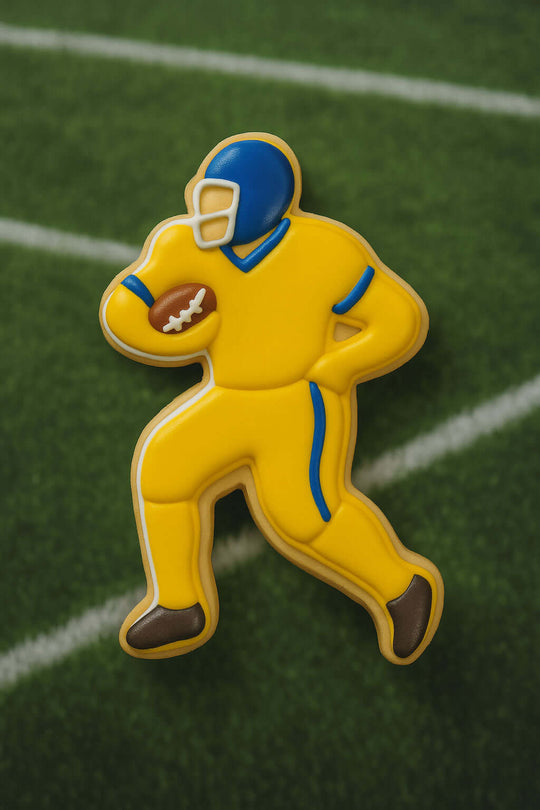 Pin of a football player in yellow uniform on a green field background from a 5 inch Football Player Metal Cookie Cutter