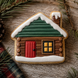 Decorative cabin cookie with a red door and green roof on a wooden surface from a 4 inch Cabin House Metal Cookie Cutter