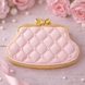 Pink quilted purse cookie with gold accents on a light wooden surface with pink roses and pearls from a 4 inch Purse Metal Cookie Cutter