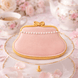 Decorative pink purse cookie on a white plate with floral teacups in the background from a 4 inch Purse Metal Cookie Cutter