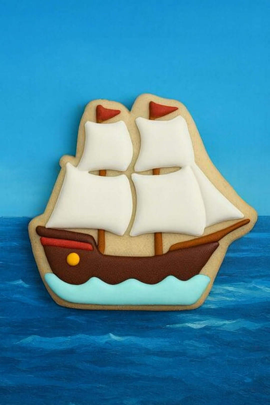 Decorative cookie shaped like a ship with sails on a blue background from a 4.25 inch Pirate Tall Sailing Ship Metal Cookie Cutter