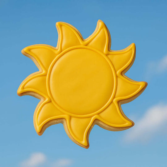 Yellow sun-shaped cookie against a blue sky from a 3.5 inch Sun Metal Cookie Cutter