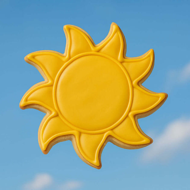 Yellow sun-shaped cookie against a blue sky from a 3.5 inch Sun Metal Cookie Cutter