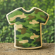 Camouflage t shirt shaped sugar cookie made with a 4 inch T Shirt Metal Cookie Cutter on a natural outdoor background