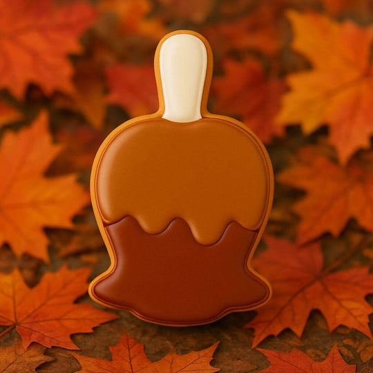Cookie-shaped like a carmel apple on orange and red autumn leaves from a 4 inch Candy Carmel Apple Metal Cookie Cutter