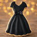 Cookie shaped like a black dress with a bow on a wooden surface with a blurred golden background from a 4 inch Dress Metal Cookie Cutter