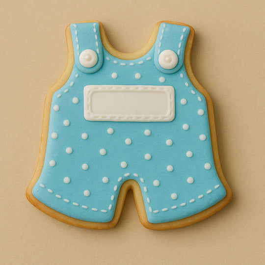 Cookie shaped like a blue polka dot romper with white buttons on a beige background from a 4 inch Baby Overalls Metal Cookie Cutter