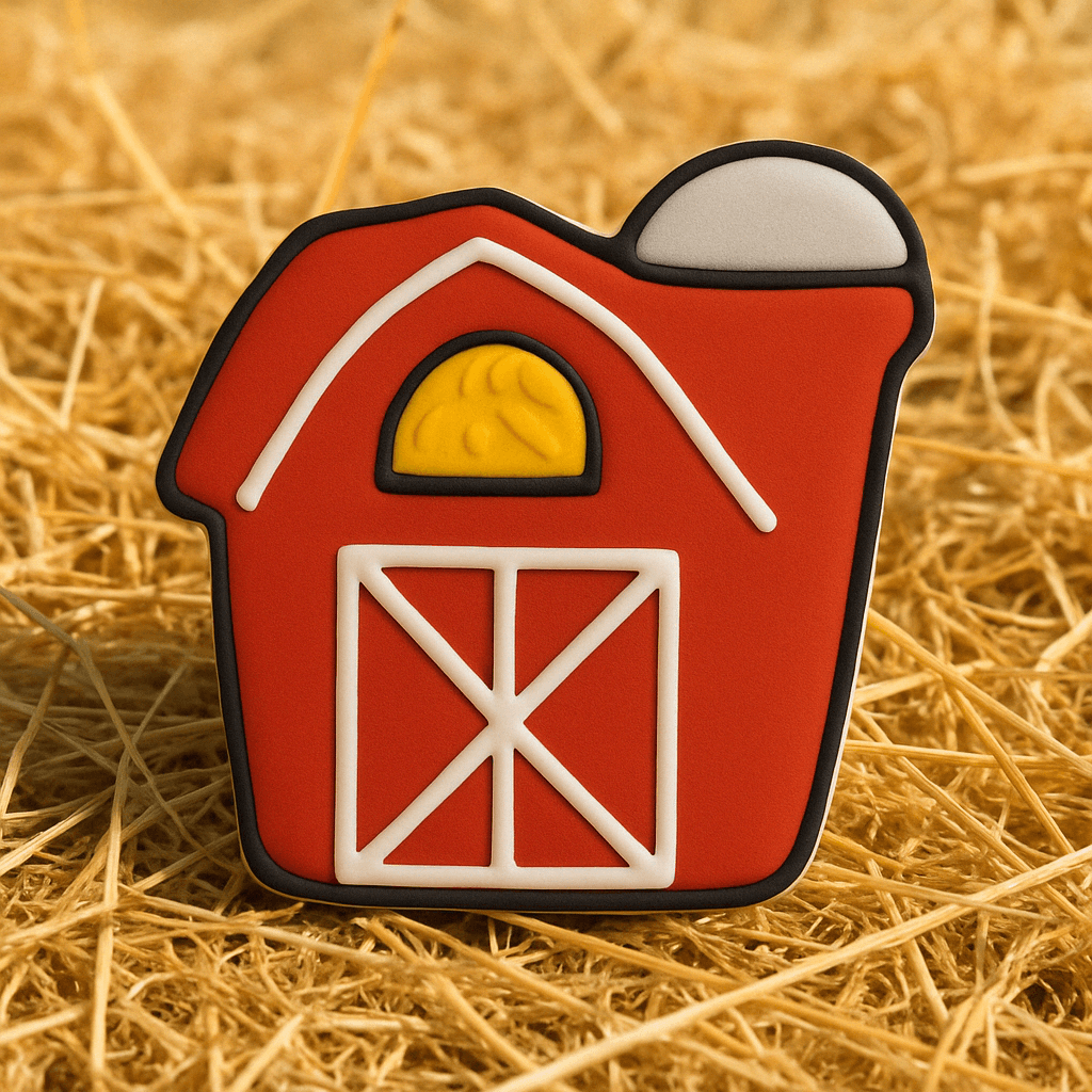 Red barn-shaped cookie on a bed of straw from a 4 inch Barn Metal Cookie Cutter