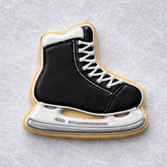 4 Inch Ice Skate Metal Cookie Cutter shaped black and white decorated cookie on an ice surface.