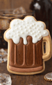 Cookie shaped like a beer mug with white foam on a wooden surface from a 4 inch Root Beer Mug Metal Cookie Cutter