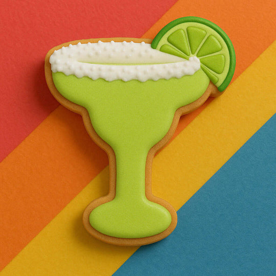 Cookie shaped like a margarita glass with lime garnish on a colorful striped background from a 4 inch Margarita Glass Metal Cookie Cutter