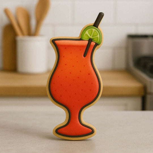 Decorative cookie shaped like a cocktail with a lime wedge on a kitchen counter from a 4 inch Hurricane Glass Metal Cookie Cutter