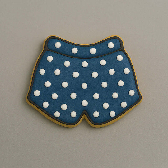 Cookie shaped like underwear with blue polka dot pattern on a beige background from a 3.5 inch Shorts or Swim Trunks Metal Cookie Cutter