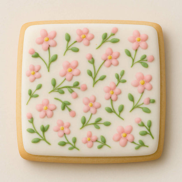 Decorative cookie with pink floral design on a beige background from a 4 inch Square Biscuit Metal Cookie Cutter