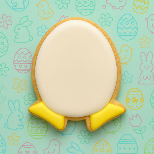 Easter-themed cookie with yellow base and white top on a patterned background from a 3.25 inch Egg with Feet Humpty Dumpty Metal Cookie Cutter