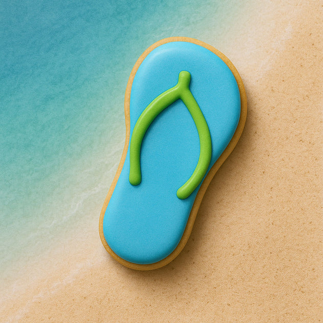 Cookie shaped like a flip-flop with blue top and green strap on a beach-themed background