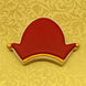 Decorative cookie shaped like a red hat with gold accents on a yellow patterned background