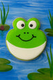 Decorative cookie shaped like a frog on a painted pond background from a 2.25 inch Frog Metal Cookie Cutter
