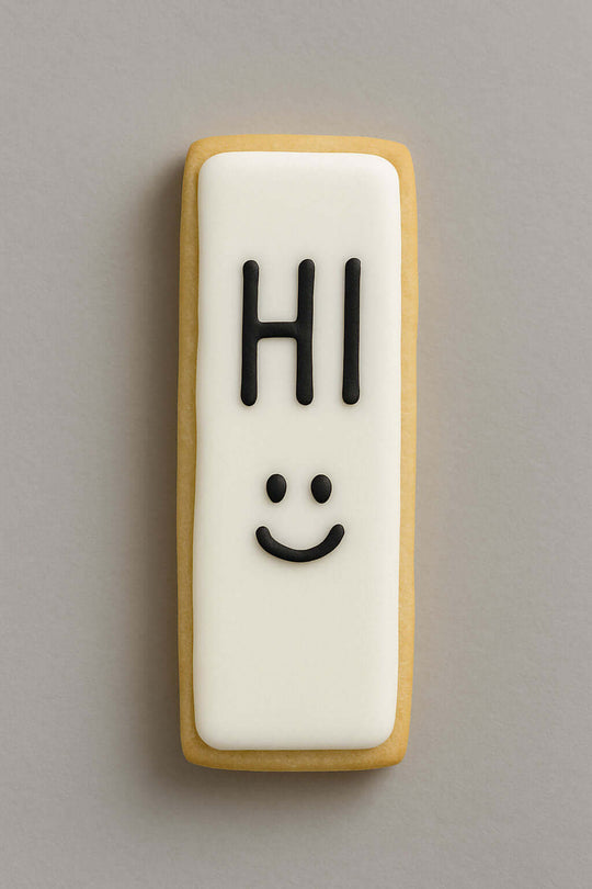 Cookie with 'HI' and a smiley face on a gray background