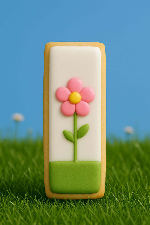 Decorative cookie with a pink flower on a grassy background from a 3.5 inch Cookie Stick Metal Cookie Cutter