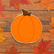 Pumpkin-shaped cookie on a wooden surface with autumn leaves from a 4 inch Pumpkin Metal Cookie Cutter