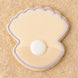 Clam shell with pearl  outlined in purple cookie on a sandy background from a 2 inch Mini Oyster Clam Shell with Pearl Metal Cookie Cutter