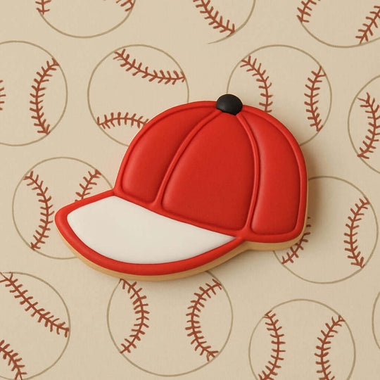 Red baseball cap cookie on a background with baseball patterns from a 2 inch Mini Baseball Cap Metal Cookie Cutter