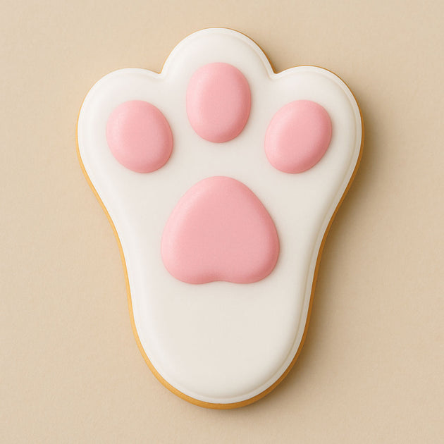 Cookie shaped like a bunny paw with pink pads on a beige background from a 2 inch Mini Bunny Rabbit Foot Metal Cookie Cutter