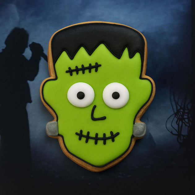 1.75 inch Mini Frankenstein Monster Metal Cookie Cutter shaped cookie decorated in green icing with white eyes.