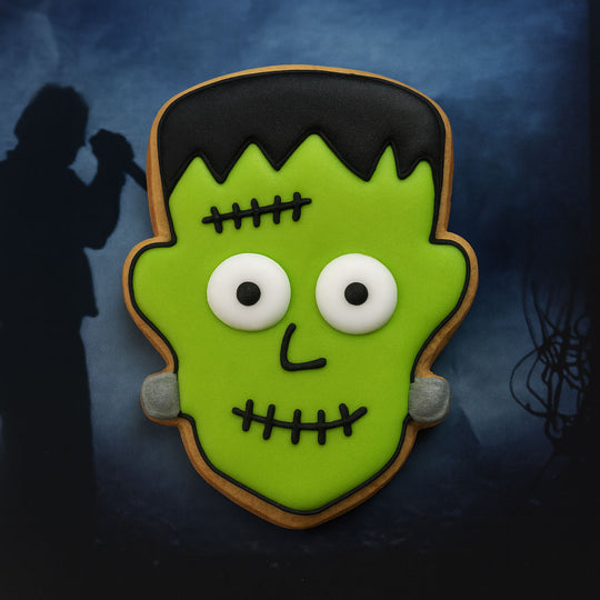1.75 inch Mini Frankenstein Monster Metal Cookie Cutter shaped cookie decorated in green icing with white eyes.