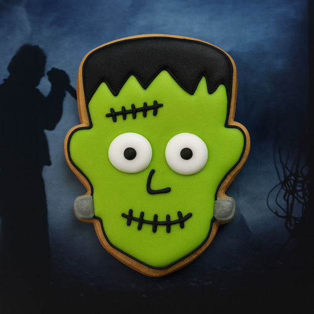 1.75 inch Mini Frankenstein Monster Metal Cookie Cutter shaped cookie decorated in green icing with white eyes.