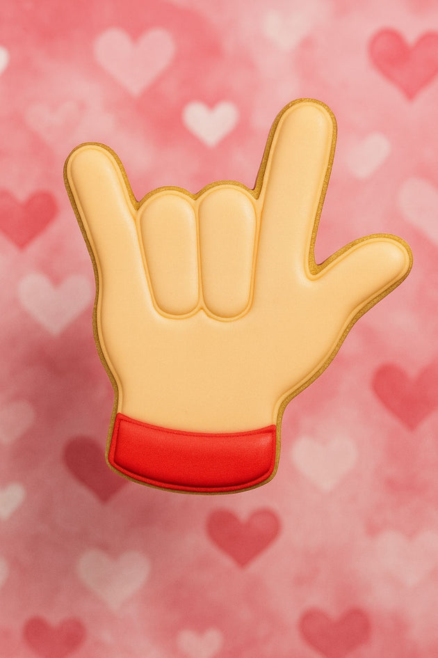 Hand sign emoji with red base on a pink background with heart shapes from a 2.25 inch Mini Love Sign Language Metal Cookie Cutter