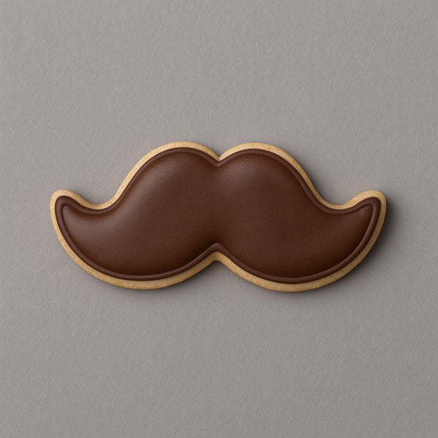 Cookie shaped like a mustache on a gray background from a 2 inch Mini Mustache Metal Cookie Cutter